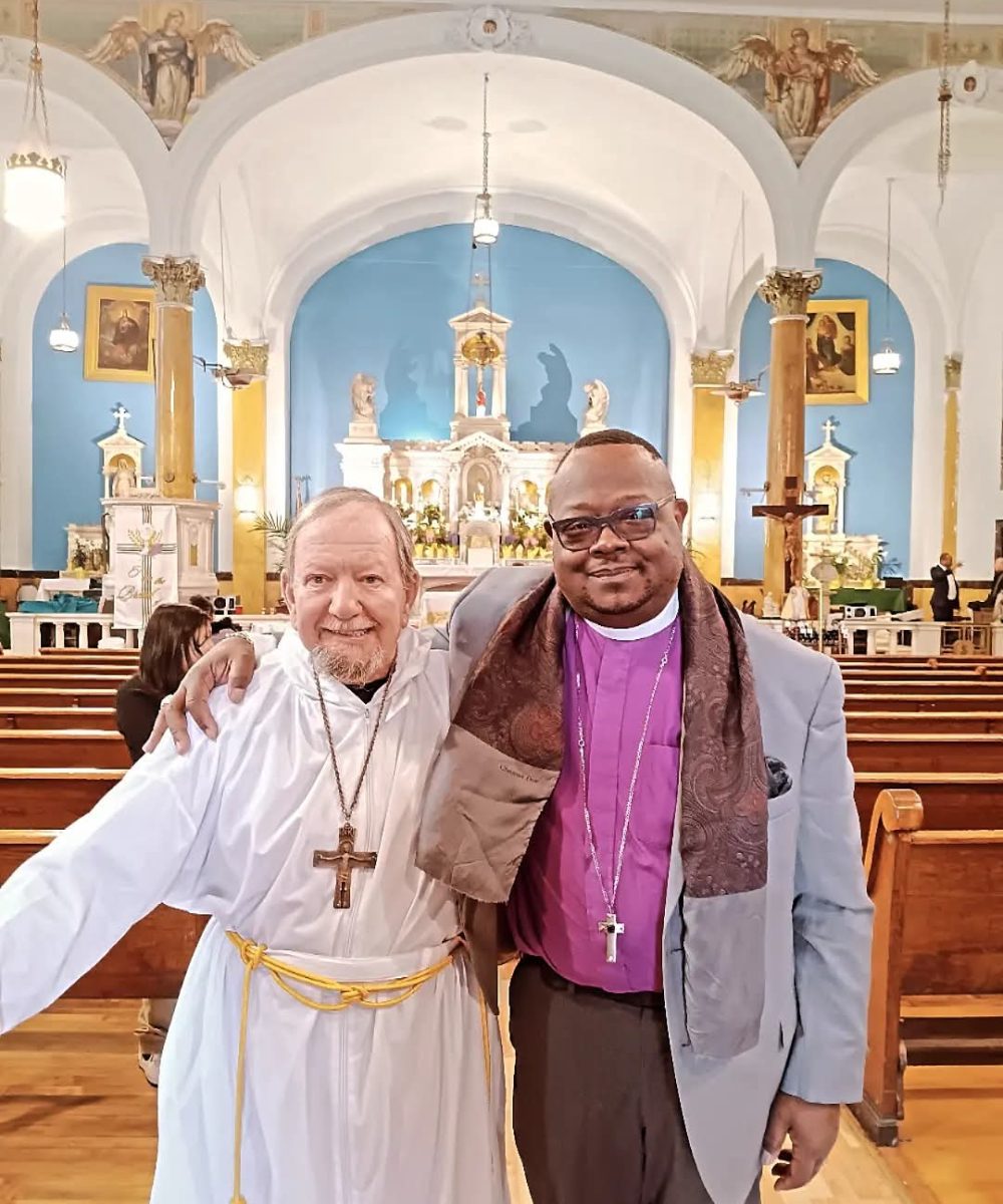 Bishop Vincent Roland in NYC with a local priest. (Violet shirt)